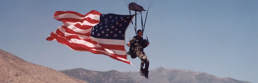 Dan Schilling under canopy with a United States flag streaming behind him