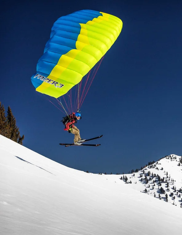 Dan Schilling speedflying under a blue and yellow wing